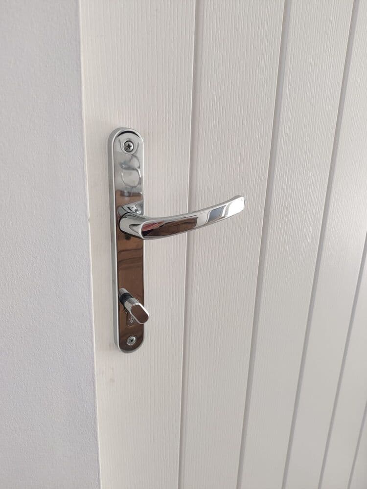A chrome lever handle fitted to a white internal door
